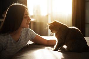 niña acaricia a su amado gato rojo foto