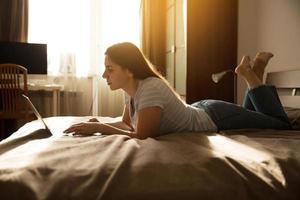 Girl is lying and looking at the laptop photo