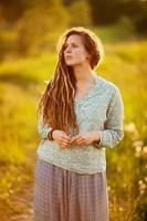 Girl with dreadlocks is standing and dreaming photo