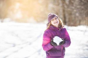 niña alegre con nieve en sus manos foto