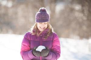 Happy woman holding snow in hands photo