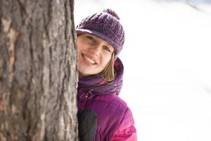 Girl in a hat costs near the tree photo