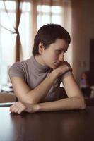 Sad woman sitting with hands clasped photo