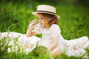 Little girl sitting and drinking photo