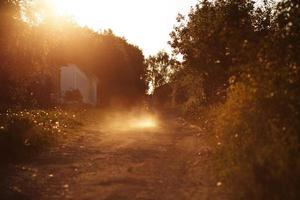 Motorcyclist riding along dusty road photo