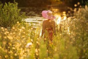 Woman with hat on the waterfront on a summer evening photo