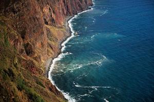 Ocean waves wash the rocky shore photo