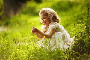 Funny happy little girl with a flower photo