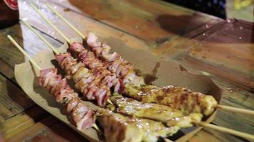 Chicken pork skewers Thai night market street food Bangkok Thailand. video