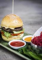 Modern fusion beef burger set with lotus chips ketchup and spicy chili sauces