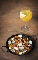 Risotto gourmet de paella de arroz y mariscos españoles con sangría de vino blanco foto