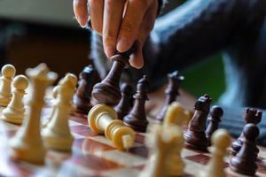Hand of business woman playing chess for game in competition success
