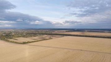 Aerial view of cereal fields after the harvest with haystack photo