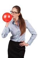 Girl with glasses inflating a red ball photo