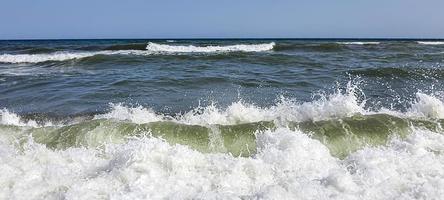 Seascape. Azure color of water, waves foaming on the shore. photo