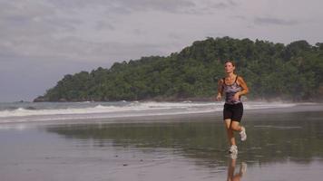 Woman out for early morning run on beach. video