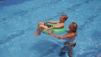 mamma och son leker i poolen. video