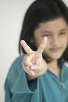 A young girl counting number with her fingers photo