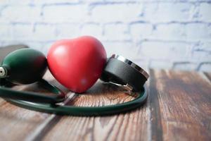 Máquina de presión arterial y forma de corazón sobre fondo blanco. foto