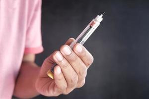 Hand hold Insulin pens against black background