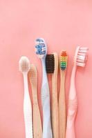 Cepillos de dientes de colores sobre fondo rosa foto