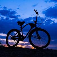 silueta de bicicleta en la hermosa puesta de sol foto