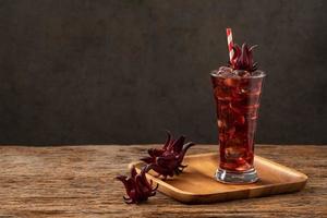 roselle clear glass with fresh roselle fruit on wooden table photo