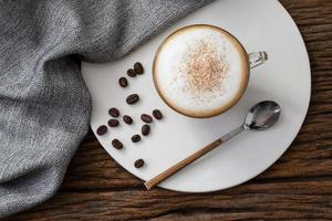 cappuccino coffee clear cup on wood background