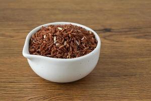 brown rice for healthy white bowl on wood background photo