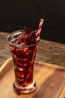 roselle clear glass with fresh roselle fruit on wooden table photo