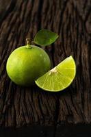 Sabor agrio fresco de lima de la selección natural sobre fondo de madera foto