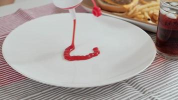 Pouring ketchup on a plate
