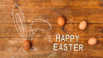 Egg on a wooden background. Chalk-drawn ears photo