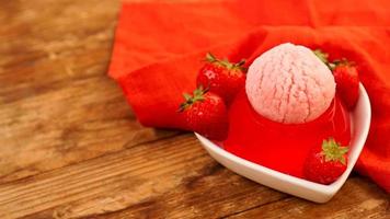 Strawberry jelly in a bowl, decorated with homemade ice cream photo