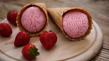 Strawberry ice cream in a waffle cone. Red berries and ice cream balls photo