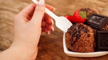 Hand with a spoon. Homemade chocolate ice cream with chocolate photo