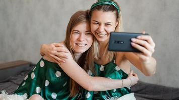 Hermosas novias felices tomando selfie con smartphone foto