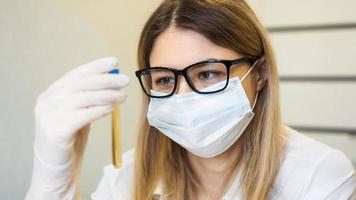 A woman holds a test tube with a urine test. photo