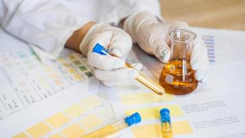 Woman making urine test with ph material in laboratory photo