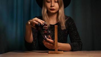 The woman witch prepares a potion. Red love potion photo