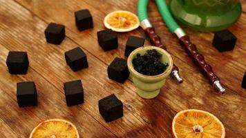 Tobacco in the bowl for hookah on wooden background photo