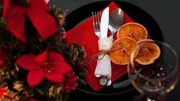 Ajuste para la cena navideña en mesa negra con decoración