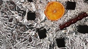 Coals for hookah on foil background with dry oranges photo