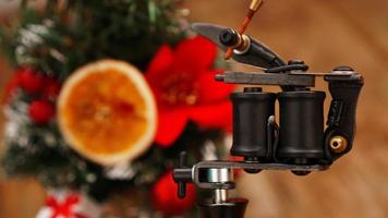 Tattoo machine on blurred christmas tree background photo