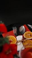 Ajuste para la cena navideña en mesa negra con decoración