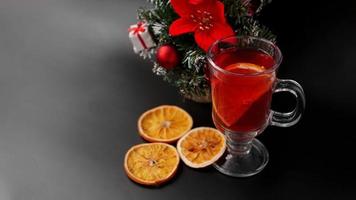 Mulled wine in glass on black table with New year decoration photo