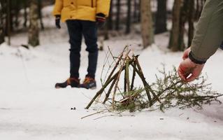 Tourists at a halt. Preparation for making a fire from spruce branches photo