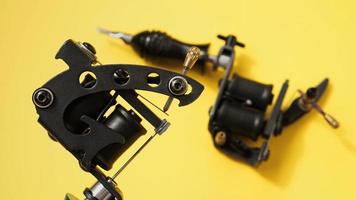 Two tattoo machines on a yellow background photo