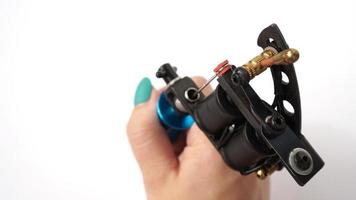 Tattoo machine on tattoo artist hand on white background photo