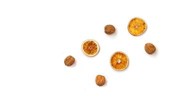 Walnuts and dry oranges on white background photo